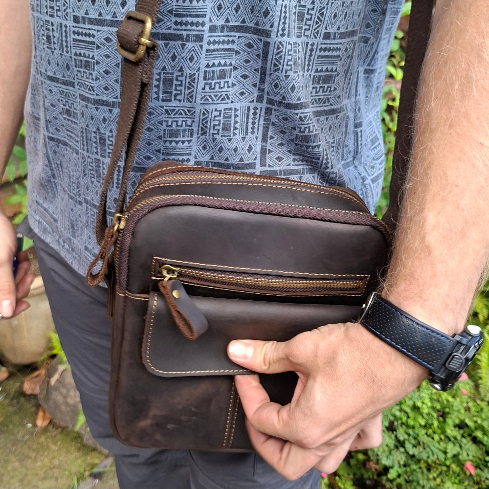 Vivace genuine leather brown sling bag worn crossbody by a person, unisex design with adjustable strap
