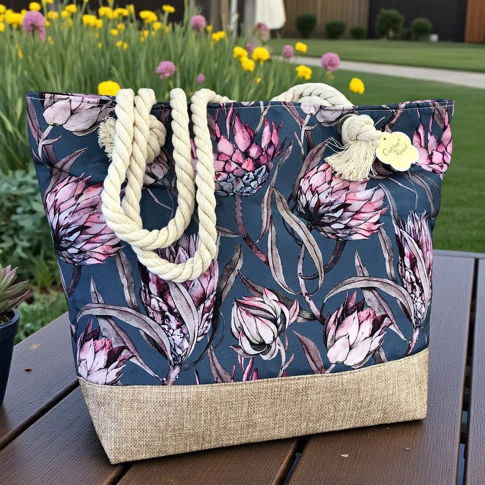 Cotton Road Beach Bag: BLUE Canvas PROTEA Print Bag with HESSIAN detailing in a garden