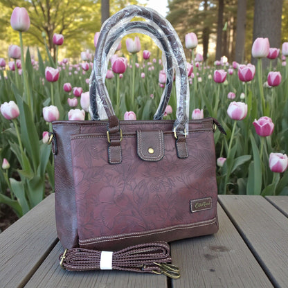 Cotton Road Brown PU leather handbag with floral pattern on a wooden table with tulips in the background