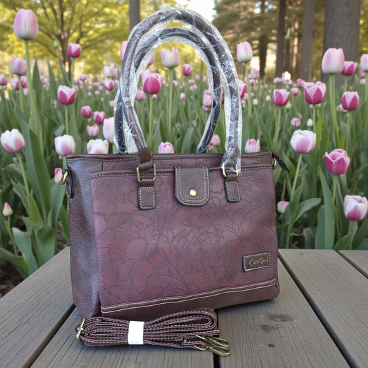 Cotton Road Brown PU leather handbag with floral pattern on a wooden table with tulips in the background