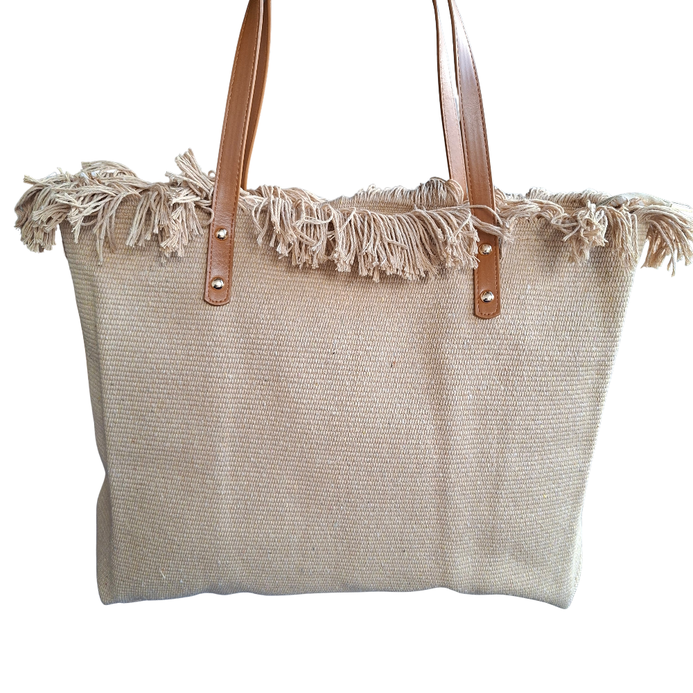Beige woven tote bag with frayed edges and brown leather handles on a white background