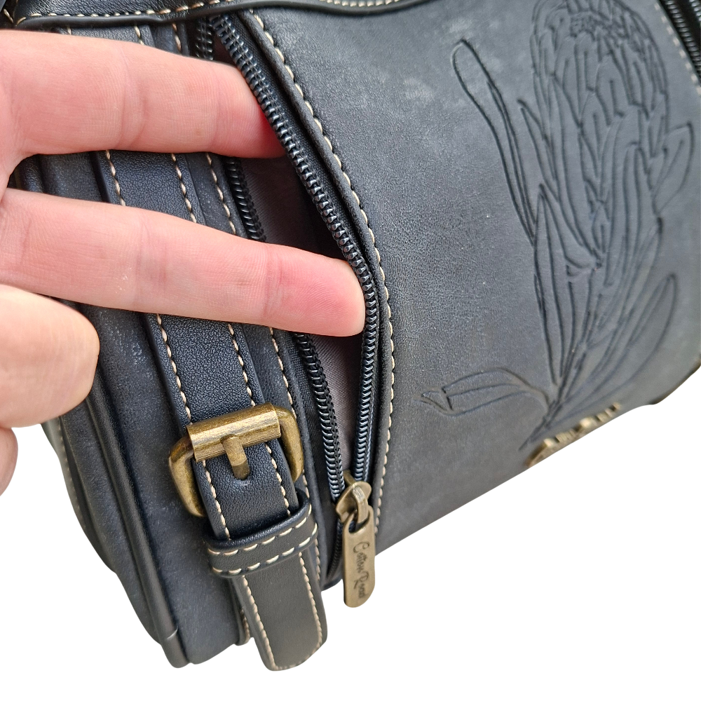 Cotton Road Sling Bag: BLACK PU Leather with Embossed PROTEA and BRANDED Strap FRONT COMPARTMENT