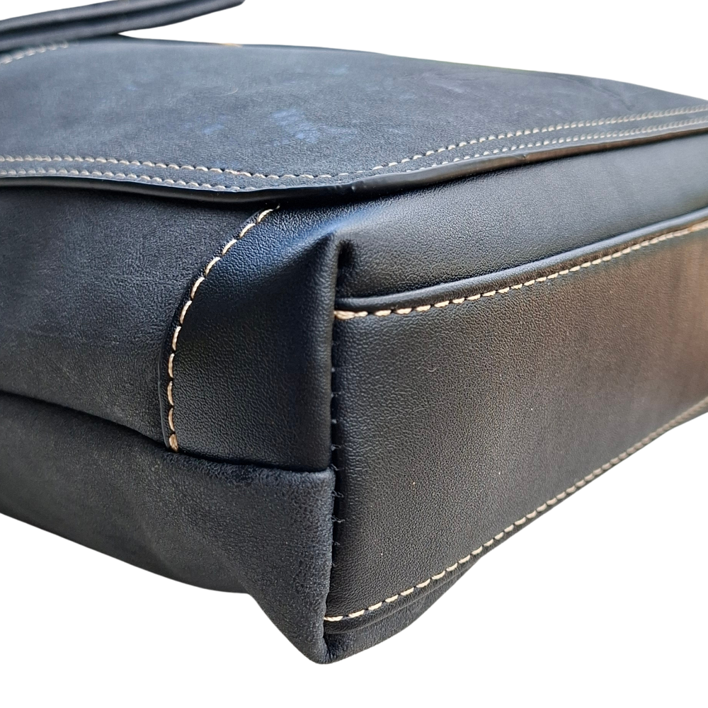 Cotton Road Sling Bag: BLACK PU Leather with Embossed Protea bottom corner view