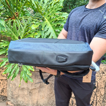 Person holding the blue/black bag VIVACE branded to show side USB port view standing outdoors.