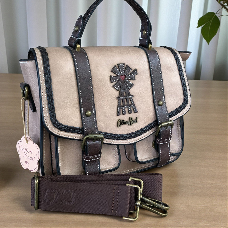 Cotton road p leather handbag with windmill decal on table. 