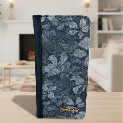 Cotton Road Wallet: Front of large black PU leather wallet with floral detailing in a bright living room