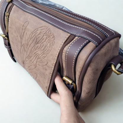 Cotton Road Sling Bag: COFFEE BROWN PU Leather Sling Bag with Protea detail