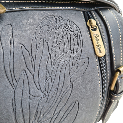 Cotton Road Sling Bag: BLACK PU Leather with Embossed PROTEA and BRANDED Strap