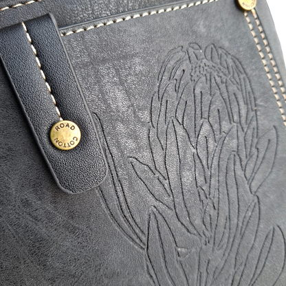 Cotton Road Sling Bag: BLACK PU Leather with Embossed Protea
