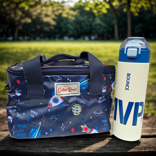 Kids combo. Dark blue Insulated lunch box bag with space design and 'Bounce' thermal water bottle on a park bench