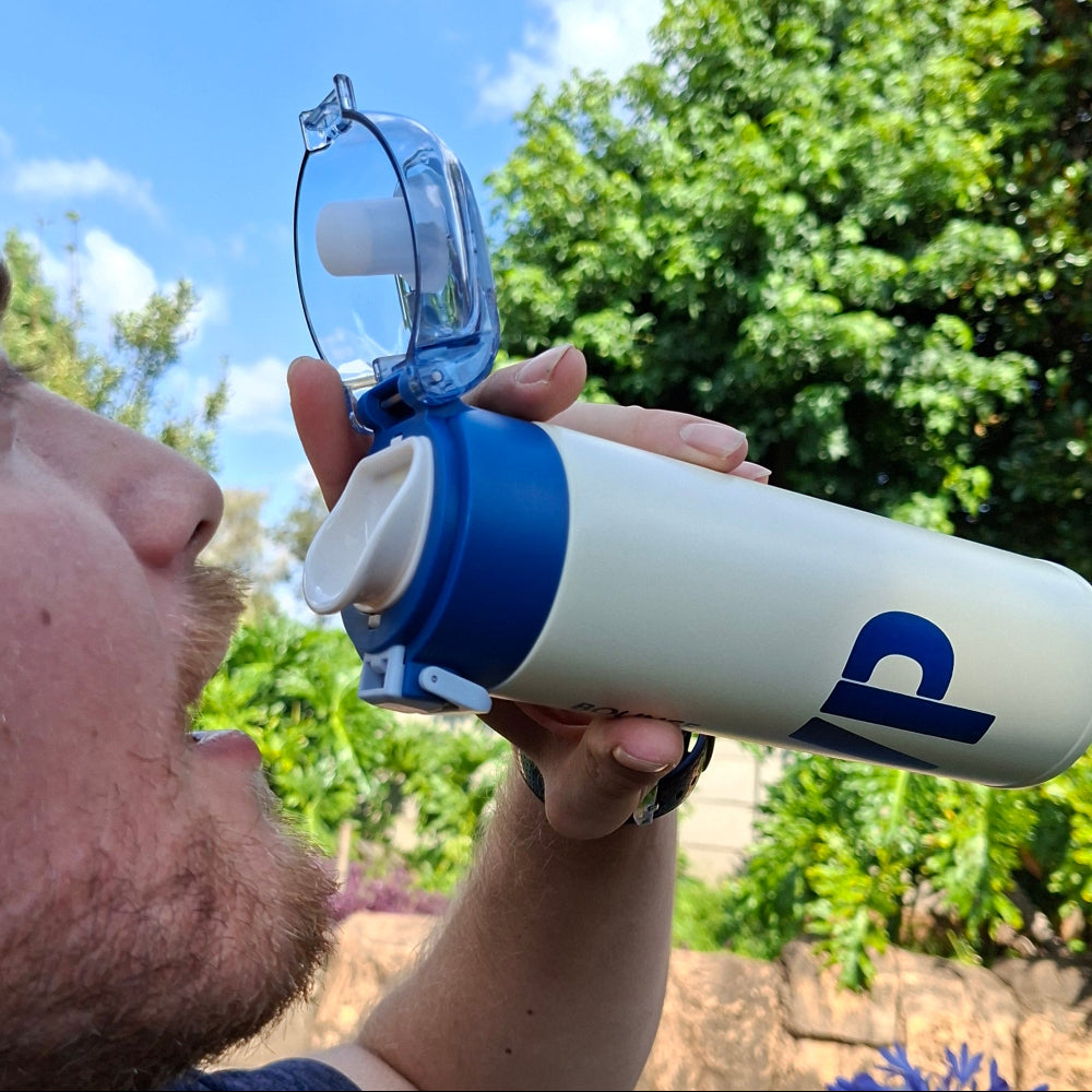 Blue slimline thermal water bottle in use, ideal for gym, school, work and outdoor activities