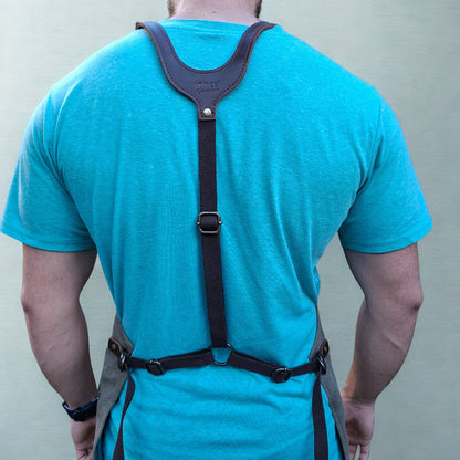 Model wearing a heavy-duty vivace waxed cotton apron showing fit on the shoulders and back